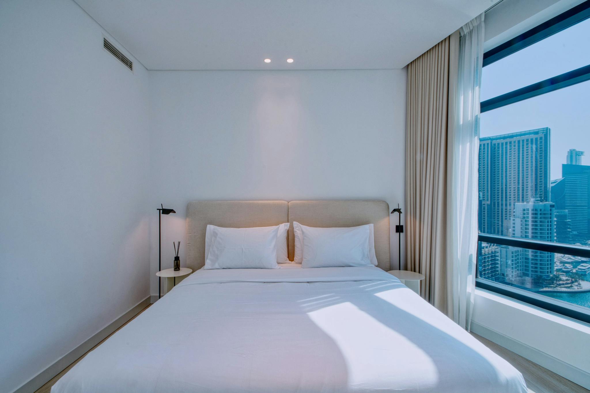 Elegant bedroom in a furnished rental with stunning cityscape view.