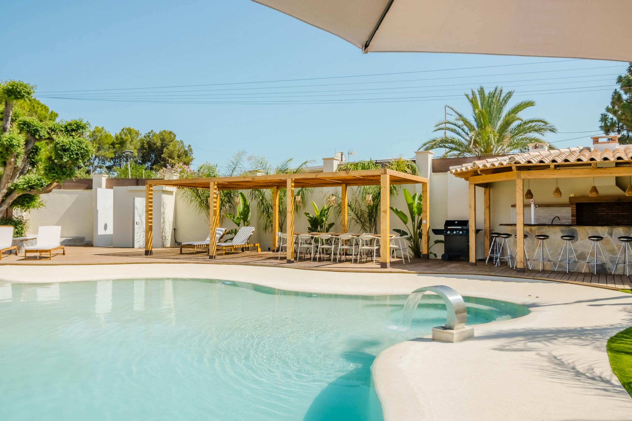 Modern villa with pool in Spain, featuring elegant architecture and outdoor dining area.